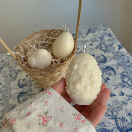 Vela en forma de huevo con dos conejitos de Pascua